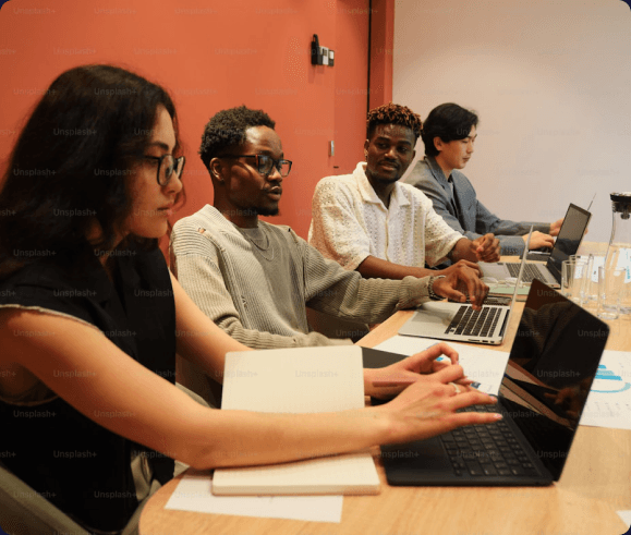Young entrepreneurs collaborating on laptops around a table